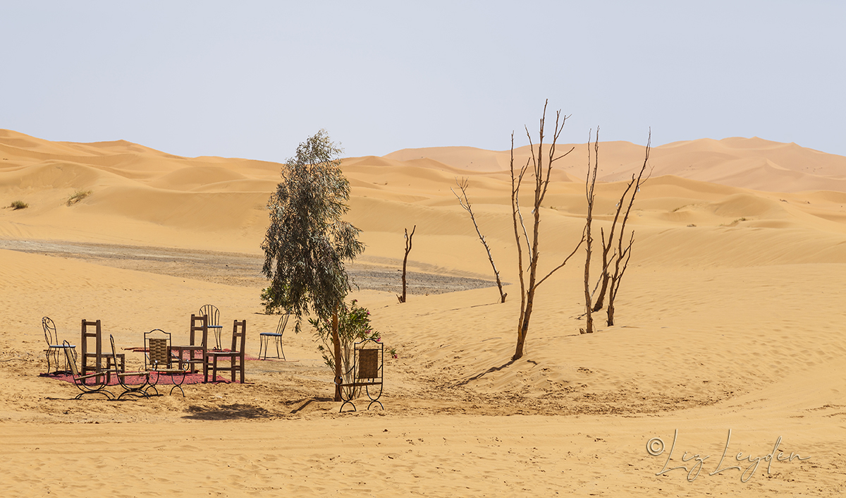 Table and chairs set out on desert sands