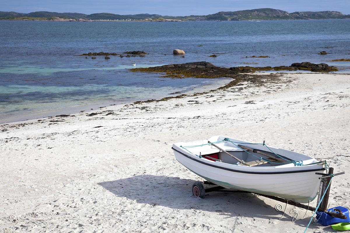 A small rowing boat a white sandy beach on the Isle of Iona, Scotland