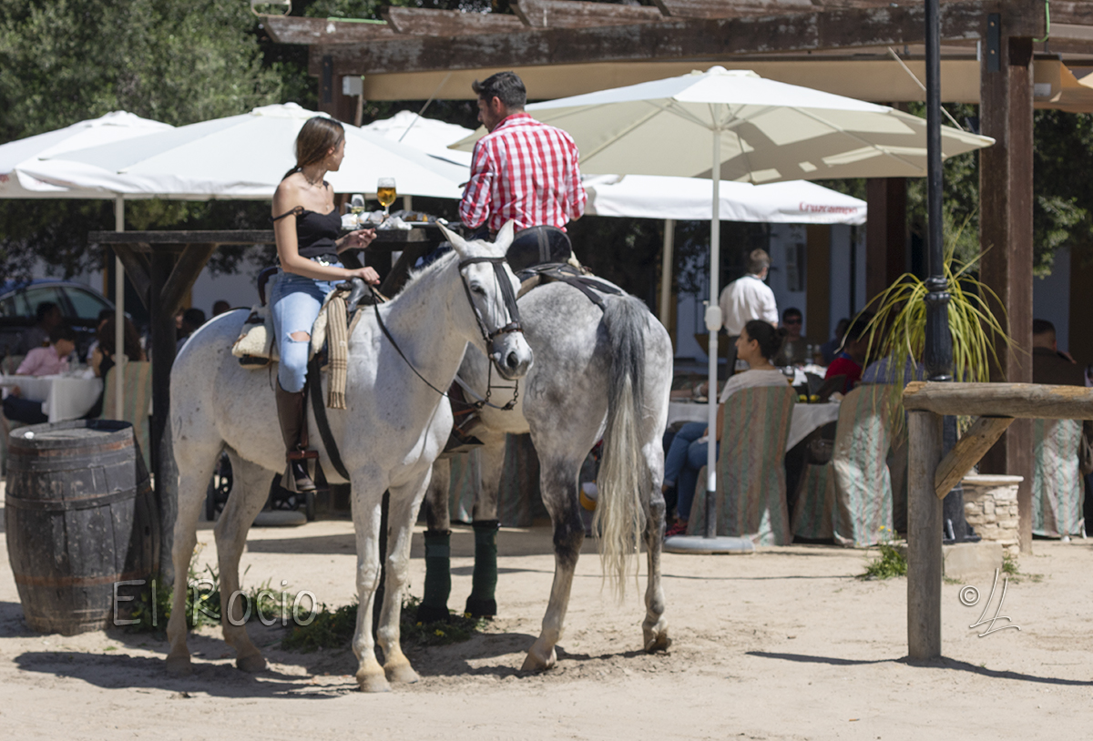 Man and woman on horseback having lunch at El Rocio.